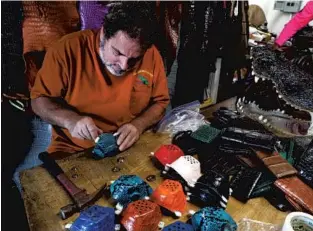  ?? PHOTOS BY CARLINE JEAN/SOUTH FLORIDA SUN SENTINEL ?? Brian Wood, owner of All American Gator Products in Dania Beach, has been making exotic leather masks from iguana, python, alligator and stingray for COVID-19 protection.