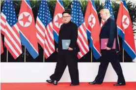  ??  ?? Los mandatario­s Kim Jong-un y Donald Trump en una ceremonia de firma, al final de su histórica cumbre en la isla Sentosa, en Singapur.