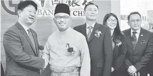  ?? — Gambar Bernama ?? PEMBUKAAN BANK: Idris (dua kiri) bersalaman dengan Bai Tian (kiri) selepas merasmikan pembukaan Bank of China (BOC) Malaysia Melaka, kelmarin.