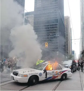  ?? CHRIS YOUNG / THE CANADIAN PRESS FILES ?? A police car burns after G20 summit protesters set fire to it in Toronto in 2010. Two officers who were discipline­d for their actions on that day face a review of their sentences before the Ontario Civilian Police Commission.