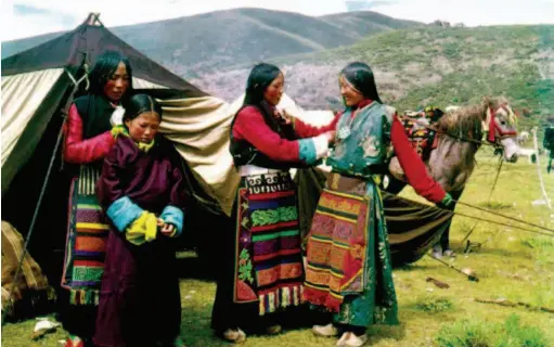  ??  ?? Tibetan women donning new clothes for the annual Horse Racing Festival in 1963. The festival, with a history of more than five centuries, is an important local entertainm­ent and trading activity. by Ru Suichu/ China Pictorial