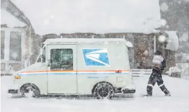  ?? THOMAS HAWTHORNE/THE REPUBLIC ?? A United States Postal Service worker delivers mail in the snow in Flagstaff on Monday.