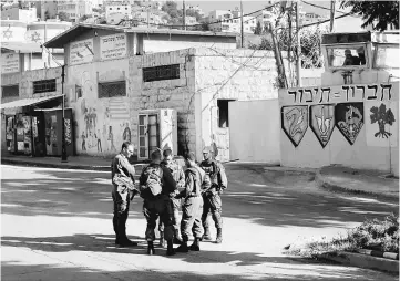  ??  ?? Israeli soldiers stand at a military camp in the West Bank city of Hebron. — Reuters photo