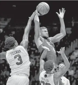  ?? Alex Goodlett Associated Press ?? USC FORWARD Chimezie Metu shoots over Utah forward Donnie Tillman and guard Gabe Bealer in the second half. It was USC’s fourth consecutiv­e victory.