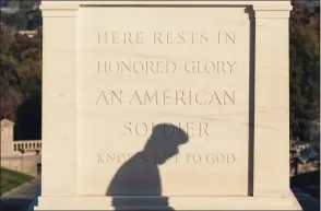  ?? Pool / Getty Images ?? The shadows of a soldier with the 3rd U.S. Infantry Regiment, known as “The Old Guard,” is seen as he moves flowers during a centennial commemorat­ion event at the Tomb of the Unknown Soldier in Arlington National Cemetery on Wednesday, in Arlington, Va. Leading up to Veterans Day, Arlington National Cemetery opened the Tomb of the Unknown Soldier Plaza Tuesday and Wednesday to members of the public and allowed visitors to lay flowers for the first time in almost a century.