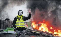  ?? AFP ?? A protester gestures near a burning barricade during a protest in Paris.