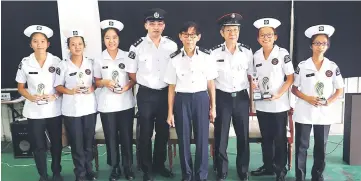  ??  ?? St John Ambulance members from SMK Kuching High with their trophies after winning the Cadet Home Nursing category. Also seen are Ang (fifth left), Yao (sixth left) and Phung (fourth left).