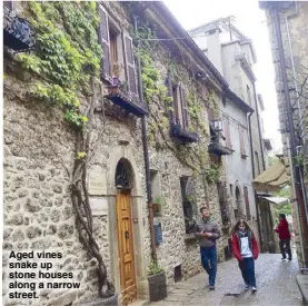  ??  ?? Aged vines snake up stone houses along a narrow street.