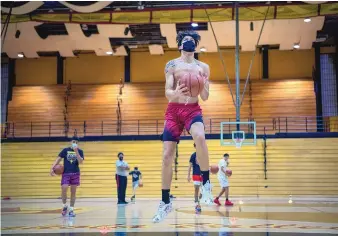  ?? EDDIE MOORE/JOURNAL ?? Ollie Fell of the Española Valley High School basketball team practices with his “pod” on Wednesday. With high school sports postponed due to the COVID-19 pandemic, the gym that is well known for amazing energy is mostly silent.