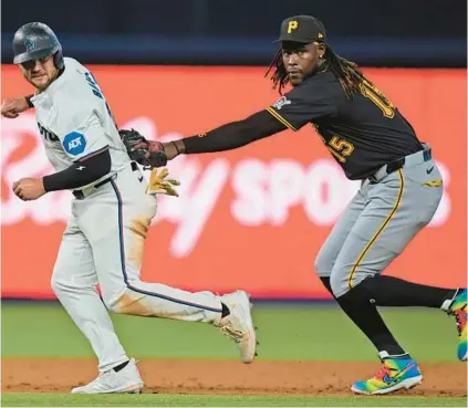  ?? WILFREDO LEE/AP ?? Pittsburgh shortstop Oneil Cruz, right, tags out the Marlins’ Jake Burger as he attempts to run to third during the third inning on Thursday in Miami.