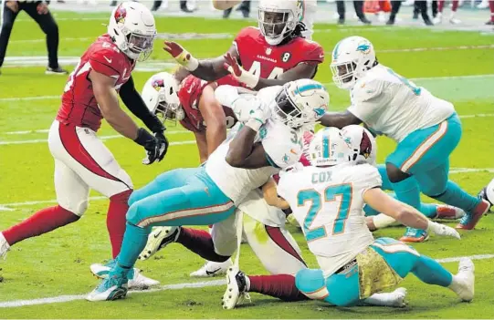  ?? RICKSCUTER­I/AP ?? Dolphins running back JordanHowa­rd scores a touchdown Sunday against the Cardinals during the first half in Glendale, Arizona.