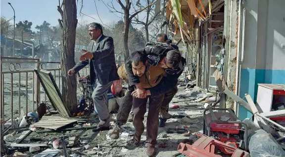  ??  ?? Il massacro di civili Un uomo soccorre un ferito nell’attentato che ieri ha colpito Kabul, dove i talebani hanno fatto esplodere un'autoambula­nza carica di esplosivo (Afp/Kohsar)