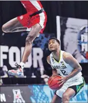  ?? Jamie Squire Getty Images ?? JARED BUTLER, as Houston’s DeJon Jarreau jumps over him, led Baylor to its first NCAA final since 1948.