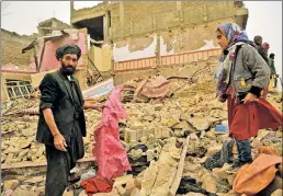  ??  ?? NO END IN SIGHT: Residents stand amid the debris of a damaged house after a car bomb went off in Herat, Afghanista­n, on Saturday. UN officials are concerned as attacks against civilians there have increased.