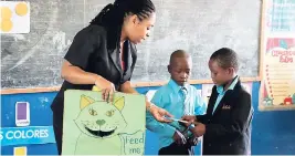  ??  ?? Grade one teacher Novelette Graham asks students to feed the cat.