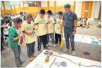  ??  ?? Children compete with each other in the robots contest.