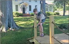  ?? / Doug Walker ?? Eagle Scout candidate Eli Mayes checks a rope on the Ridge ferry replica he built for the Major Ridge Home/Chieftains Museum.