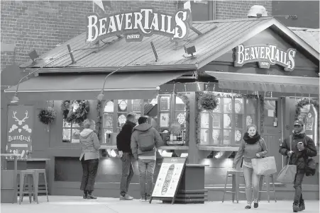  ??  ?? People line up to order outside a BeaverTail­s stand in Ottawa's Byward Market on Thursday.