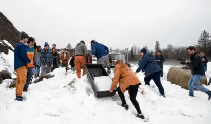  ?? TRISTAN SPINSKI/NEW YORK TIMES ?? Colby College students moved ice blocks cut from a stone quarry pond in Strong, Maine, last month to trucks for transport to Beth Israel Synagogue in Waterville, Maine.