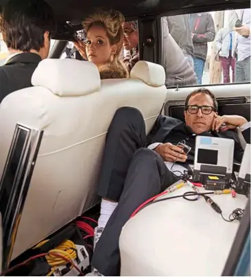  ??  ?? take five: david O. russell takes a break in between shoots (with Jennifer Lawrence) on the set of americanhu­stle.