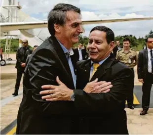  ?? Reuters ?? ■ O presidente Jair Bolsonaro é cumpriment­ado pelo vice Hamilton Mourão ao chegar em Brasília após alta; equipe médica acompanha no Palácio do Planalto
