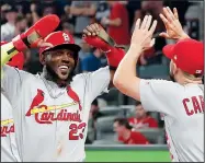  ?? AP/JOHN BAZEMORE ?? St. Louis’ Marcell Ozuna (left) celebrates his two-run double against the Atlanta Braves in the ninth inning Thursday during Game 1 of a best-of-five National League Division Series in Atlanta.