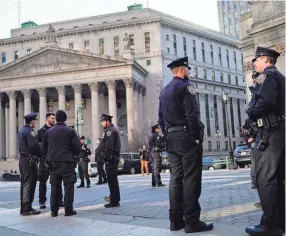  ?? EDUARDO MUNOZ ALVAREZ/AP ?? Officers in New York City gather Tuesday outside a federal courthouse in the city. A New York grand jury investigat­ing Trump over a hush money payment to a porn star appears poised to complete its work soon as law enforcemen­t officials make preparatio­ns for possible unrest in the event of an indictment.