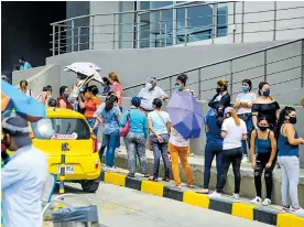  ?? ORLANDO AMADOR ?? Un grupo de personas realizan una fila a las afueras de un local.