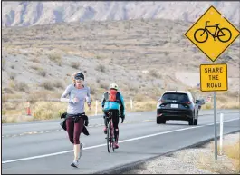  ?? STEVE MARCUS (2021) ?? A jogger, a cyclist, and a car share the road on Highway 159 near the Red Rock Canyon National Conservati­on Area. The area is popular with joggers, hikers, cyclists, campers and others, recording more than 3.7 million visitors already this year.