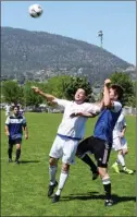  ?? DAVID CROMPTON/Penticton Herald ?? Penticton Tim Hortons Pinnacles (blue jerseys) and PoCo Legends players battle for a high ball during the men’s A final of the May Classic soccer tournament on Monday at King’s Park.The Pinnacles beat the Legends 3-0.