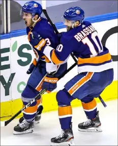  ?? Elsa/Getty Images ?? New York Islanders forward Mathew Barzal, left, celebrates with Derick Brassard after scoring the winning goal against the Washington Capitals in the first overtime period of Game 3 of the Eastern Conference first round series Sunday at Scotiabank Arena in Toronto. New York leads the series 3-0.