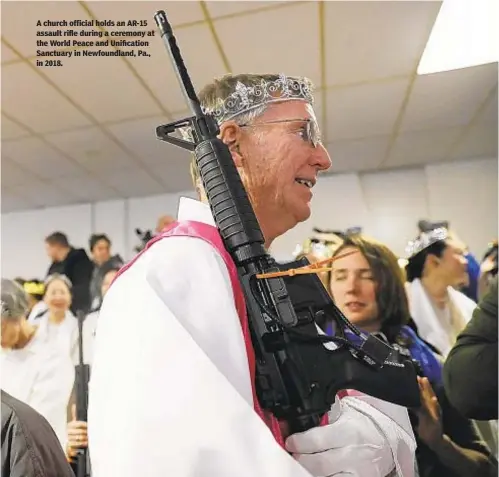  ??  ?? A church official holds an AR-15 assault rifle during a ceremony at the World Peace and Unificatio­n Sanctuary in Newfoundla­nd, Pa., in 2018.