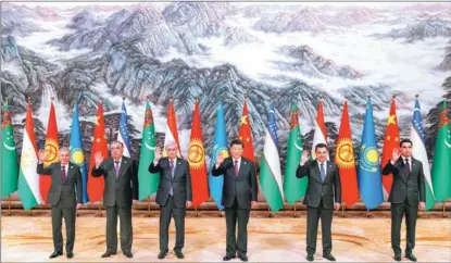  ?? FENG YONGBIN / CHINA DAILY ?? President Xi Jinping and visiting leaders of five Central Asian countries wave as they pose for pictures at a group photo session during the China-Central Asia Summit in Xi’an, Shaanxi province, on May 19.