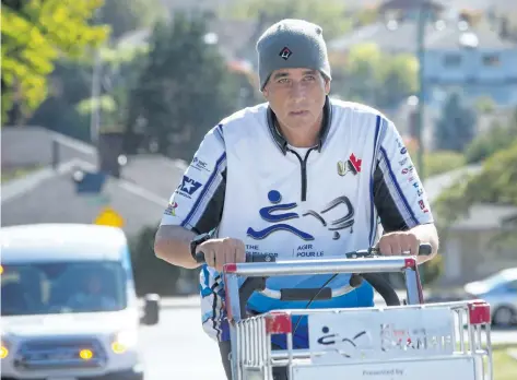  ?? BEN NELMS/THE CANADIAN PRESS ?? Joe Roberts, a former homeless youth, is pictured pushing his shopping cart up a street in Burnaby, B.C., on Tuesday. Roberts’ journey to raise awareness for homeless youth by walking across Canada began in St. John’s, N.L., 17 months ago and will end...