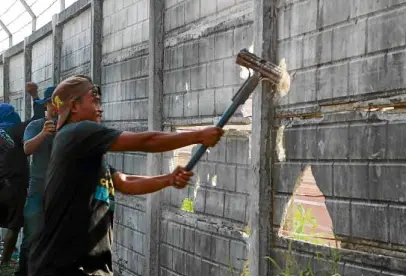  ?? —CONTRIBUTE­D PHOTO ?? FORCIBLE ENTRY Farm workers tear down the concrete fence put up by Rizal Commercial Banking Corp. in an attempt to gain entry to 500 hectares bought by the bank from the Cojuangcos in Hacienda Luisita in Tarlac province.