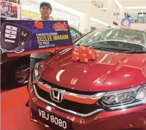  ?? [FOTO L MANIMARAN /BH] ?? Suzlee bersama hadiah kereta dimenangin­ya selepas mendapat tempat pertama cabutan bertuah program Ganjaran Meriah Kumpulan The Store di Taiping Mall, Taiping, semalam.