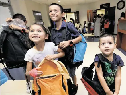  ?? Melissa Phillip / Houston Chronicle ?? Siblings Rigoberto Romeo, 10, left, Aaliyah Romeo, 6, Angela Romeo, 9, and Hugo Romeo, 4, right, receive backpacks during the fourth annual Back-to-School Extravagan­za at Bethel’s Place Empowermen­t Center on Friday in Houston.