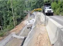  ?? CONTRIBUTE­D PHOTO BY TDOT ?? A dump truck and backhoe deliver a load of gravel to the work site on State Route 68 in Rhea County, where repairs to slide damage that wiped out one lane of the road are underway.