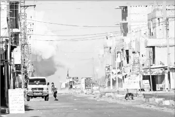  ??  ?? File photo shows a man fleeing as smoke plumes rise from regime bombardmen­t in Al-Hirak in the eastern Daraa province countrysid­e in southern Syria. — AFP photo