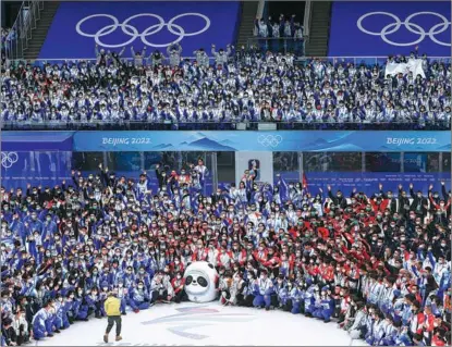  ?? HEI JIANJUN / FOR CHINA DAILY ?? Volunteers and staff workers at the Beijing 2022 Winter Olympics pose on Feb 21 for a group photo at the National Stadium. The closing ceremony of the Games was held at the venue on Feb 20.