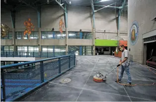  ?? LUIS SÁNCHEZ SATURNO/THE NEW MEXICAN ?? Nathan Martinez, building supervisor at Chavez Community Center, polishes a floor Monday.