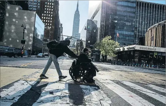  ?? KENA BETANCUR / AFP ?? Dos personas cruzando ayer la calle 34 de Manhattan