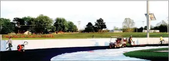  ?? MARK HUMPHREY ENTERPRISE-LEADER ?? Workers spray the surface of a newly redone track at Lincoln High School on May 5. As of June 13 work has been completed and the track is ready for use. The surface has been finished and is for walking, jogging and running only. The school asks the...