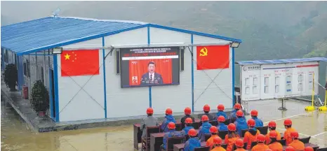  ?? FOTOS: DPA / AFP ?? Chinas Staats- und Parteichef Xi Jinping verspricht seinen Landsleute­n beim Parteikong­ress der Kommuniste­n in Peking eine sonnige Zukunft – Bauarbeite­r in Congjiang verfolgen die Rede auf einem Großbildsc­hirm.