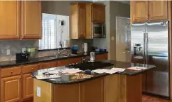  ??  ?? Before, the kitchen had wood-stained cabinets, a dark counter and an irregular-shaped island, common in homes built 20 years ago.