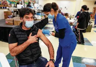  ?? Marvin Pfeiffer / Staff photograph­er ?? Erwin Richter, 49, gets his first COVID-19 vaccinatio­n shot March 24 from Clara Del Bosque of St. Philips College at WellMed’s Elvira Cisneros Senior Community Center.