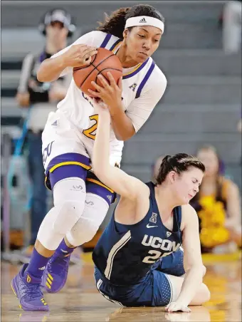  ?? GERRY BROOME/AP PHOTO ?? East Carolina’s Salita Greene, left, and UConn’s Kyla Irwin battle for a loose ball during Wednesday’s game in Greenville, N.C. The top-ranked Huskies routed the Pirates 96-35 to remain unbeaten.