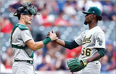  ?? RON SCHWANE / AP ?? Oakland Athletics relief pitcher Dany Jiménez (56) and catcher Sean Murphy celebrate the team’s win against the Cleveland Guardians in a baseball game on Saturday in Cleveland.