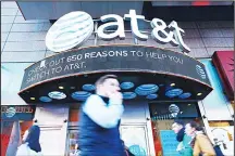  ??  ?? People walk past an AT&T store in New York on Oct 23. AT&T unveiled a mega-deal for Time Warner that would transform the telecom giant into a media-entertainm­ent powerhouse positioned for a sector facing major technology changes. The stock-and-cash...