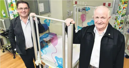  ?? PHOTO: GREGOR RICHARDSON ?? In memory . . . Fin Heads (right) presents Southern District Health Board chief executive Chris Fleming with an electronic cot for the children’s ward at Dunedin Hospital.